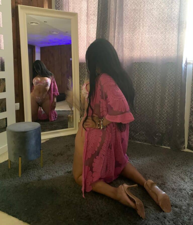 Mujer en lencería rosa frente al espejo